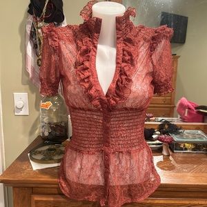 Blush colored dressy button up top with ruffle sleeve and high collar